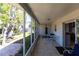 View of the screened porch with tile floor and outdoor furniture, offering a seamless transition to the backyard at 1516 Saint Clair Rd, Englewood, FL 34223
