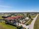 Expansive aerial view showcases a community with red-tiled roofs, surrounding greenery, and distant city skyline at 17200 Acapulco Rd # 123, Punta Gorda, FL 33955