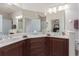 Bathroom featuring dual sinks, granite countertops, and a large vanity mirror at 17200 Acapulco Rd # 123, Punta Gorda, FL 33955
