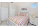 Light-filled bedroom with a bed featuring striped linens and white furniture at 17200 Acapulco Rd # 123, Punta Gorda, FL 33955