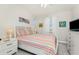 Bright bedroom featuring striped comforter and white wooden furniture at 17200 Acapulco Rd # 123, Punta Gorda, FL 33955