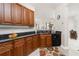 Functional kitchen area with dark countertops, wooden cabinets, and easy access to adjacent dining space at 17200 Acapulco Rd # 123, Punta Gorda, FL 33955