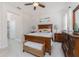 Spacious main bedroom featuring wood furniture, a ceiling fan, and neutral decor at 17200 Acapulco Rd # 123, Punta Gorda, FL 33955