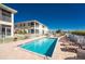 Community pool with lounge chairs, tables, and well-maintained landscaping and building exterior at 17200 Acapulco Rd # 123, Punta Gorda, FL 33955