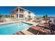 Swimming pool with lounge seating and a view of the screened in porch and buildings beyond at 17200 Acapulco Rd # 123, Punta Gorda, FL 33955