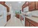 Functional kitchen with wooden cabinets, white appliances, and easy access to the dining area at 1808 Kings Gate Ct, Punta Gorda, FL 33980