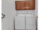Practical laundry room with washer, dryer, and upper cabinets for convenient storage at 1808 Kings Gate Ct, Punta Gorda, FL 33980