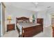 Well-lit main bedroom with wood furniture, neutral bedding, and a ceiling fan, creating a cozy space at 1808 Kings Gate Ct, Punta Gorda, FL 33980