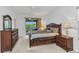 Spacious main bedroom with dark wood furniture, plush bedding, and a private outdoor patio space at 1808 Kings Gate Ct, Punta Gorda, FL 33980