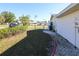 Fenced back yard with rock garden, a side entrance to the house, and lawn at 22191 New Rochelle Ave, Port Charlotte, FL 33952