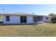 A well-maintained backyard featuring a white house with a screened-in porch and green grass at 22191 New Rochelle Ave, Port Charlotte, FL 33952