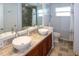 Bathroom with double sinks, a walk-in shower with gray tiling, and a window at 22191 New Rochelle Ave, Port Charlotte, FL 33952