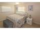 Cozy bedroom featuring tiled floors, two windows, a bed with matching pillows, and side table at 22191 New Rochelle Ave, Port Charlotte, FL 33952