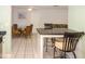 An open-plan dining area with wicker furnishings and lots of space, next to the kitchen bar at 22191 New Rochelle Ave, Port Charlotte, FL 33952