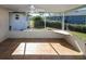View of the screened porch with tile flooring, a ceiling fan, and an outdoor countertop at 22191 New Rochelle Ave, Port Charlotte, FL 33952