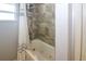 Shower and bathtub area with brown tiling, shower caddy, and window at 22191 New Rochelle Ave, Port Charlotte, FL 33952