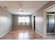 A neutral bedroom with tile floors, ceiling fan, two windows, and an adjoining bathroom at 23179 Maclellan Ave, Port Charlotte, FL 33980