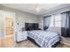Comfortable bedroom with plaid comforter, side table, and dark curtains at 23179 Maclellan Ave, Port Charlotte, FL 33980