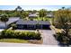 Aerial view of a single story home featuring a driveway and manicured landscaping in a lush neighborhood at 23179 Maclellan Ave, Port Charlotte, FL 33980