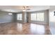 Open living room with tile floors, neutral paint, ceiling fan, and windows overlooking a scenic outdoor view at 23179 Maclellan Ave, Port Charlotte, FL 33980