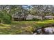 Spacious backyard offers a serene setting with mature trees, lush lawn, and waterfront views at 238 Southampton Dr # 319, Venice, FL 34293