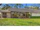 Backyard view of home featuring glass enclosed porch and outdoor dining furniture at 238 Southampton Dr # 319, Venice, FL 34293