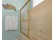Clean bathroom featuring glass shower door, white ceramic tiling, and a white towel at 238 Southampton Dr # 319, Venice, FL 34293