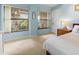 Bedroom with large windows looking out on green plants, light blue walls at 238 Southampton Dr # 319, Venice, FL 34293