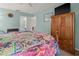 Bright bedroom featuring a wood bed frame, an armoire, and ensuite bathroom at 238 Southampton Dr # 319, Venice, FL 34293