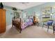 Comfortable bedroom featuring a wood-framed bed, carpeted floors, and natural light at 238 Southampton Dr # 319, Venice, FL 34293