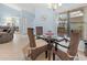 Bright dining area with glass table and wicker chairs with views to the living room at 238 Southampton Dr # 319, Venice, FL 34293