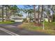 Inviting one-story home with mature landscaping, a gray tile roof, and an attached two-car garage at 238 Southampton Dr # 319, Venice, FL 34293