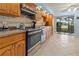 Well-lit kitchen with stainless steel oven, tile backsplash, light wood cabinetry, and water view at 238 Southampton Dr # 319, Venice, FL 34293