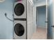 Stacked washer and dryer in laundry space adjacent to hallway, blue wall paint at 238 Southampton Dr # 319, Venice, FL 34293