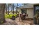 Back patio with four chairs around a table, with a green lawn and trees at 238 Southampton Dr # 319, Venice, FL 34293