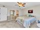 Bedroom with a ceiling fan, sunset artwork, and access to a bathroom at 240 Lewis Cir # 28, Punta Gorda, FL 33950