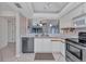 Open kitchen featuring stainless steel appliances, white cabinets, and views to living room at 240 Lewis Cir # 28, Punta Gorda, FL 33950