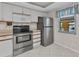 Bright kitchen featuring stainless steel appliances, white cabinets, and a window at 240 Lewis Cir # 28, Punta Gorda, FL 33950