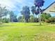Expansive grassy backyard with mature palm trees, providing a private outdoor space at 2715 Taylor Rd, Punta Gorda, FL 33950