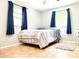 This bedroom offers natural light through two windows with matching blue curtains at 2715 Taylor Rd, Punta Gorda, FL 33950