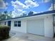 Attached single-car garage with an adjacent walkway that leads to the front door at 2715 Taylor Rd, Punta Gorda, FL 33950