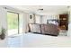 Bright living room with a leather sofa, sliding glass doors, and neutral-toned walls at 2715 Taylor Rd, Punta Gorda, FL 33950
