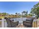 Cozy balcony with wicker chairs overlooking a serene canal with palm trees, perfect for enjoying the view at 301 Palmetto Ne Dr, Port Charlotte, FL 33952