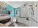Modern bathroom with a glass-enclosed shower, stylish sink, and turquoise accent wall at 301 Palmetto Ne Dr, Port Charlotte, FL 33952