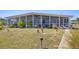 Charming home with a screened-in porch and well-manicured lawn featuring decorative flamingo ornaments at 301 Palmetto Ne Dr, Port Charlotte, FL 33952