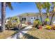 Attractive single-story home with a garden and lush tropical landscaping, creating a warm welcome at 301 Palmetto Ne Dr, Port Charlotte, FL 33952