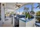 Outdoor kitchen on the screened-in porch with a built-in grill and beautiful tile work at 301 Palmetto Ne Dr, Port Charlotte, FL 33952