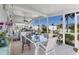 Relaxing screened-in patio featuring a dining table and chairs overlooking a nicely landscaped yard with palm trees at 301 Palmetto Ne Dr, Port Charlotte, FL 33952