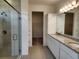 Main bathroom with granite counters, dual sinks, glass shower, and a walk-in closet at 354 Porto Alegre St, Punta Gorda, FL 33983