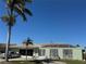 Exterior view of a house with palm trees, an American flag, a car in the driveway, and a well-maintained yard at 548 Belvedere Ct, Punta Gorda, FL 33950